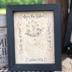 When the Flakes Primitive Stitchery Framed Print