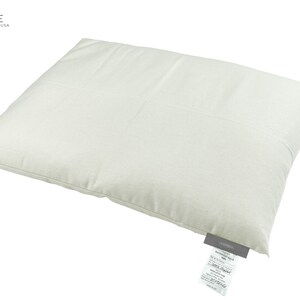 Peut inclure: Un oreiller rectangulaire blanc avec une &eacute;tiquette blanche fix&eacute;e au coin inf&eacute;rieur. L'&eacute;tiquette porte un texte noir qui dit "I SLEEP SIMPLE" et "Nature + Organic Made in the USA".