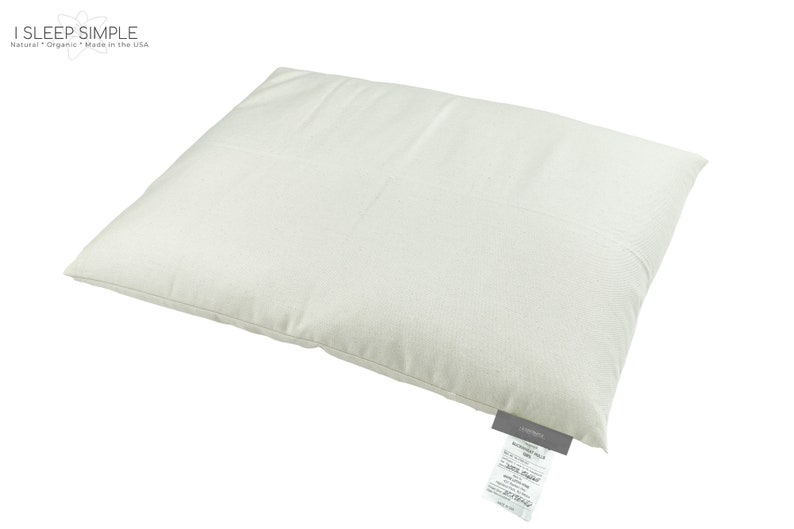 Peut inclure: Un oreiller rectangulaire blanc avec une &eacute;tiquette blanche fix&eacute;e au coin inf&eacute;rieur. L'&eacute;tiquette porte un texte noir qui dit "I SLEEP SIMPLE" et "Nature + Organic Made in the USA".