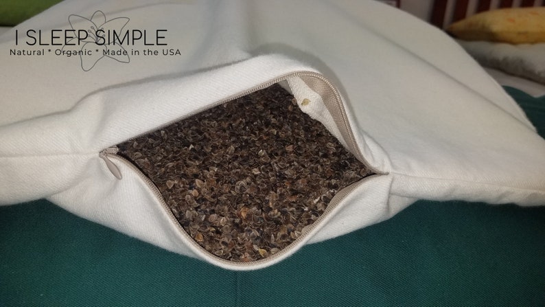 Peut inclure: Une taie d'oreiller blanche avec une fermeture &eacute;clair ouverte, r&eacute;v&eacute;lant un oreiller en coque de sarrasin &agrave; l'int&eacute;rieur. La taie d'oreiller porte l'inscription "I SLEEP SIMPLE. Natural * Organic * Made in the USA".