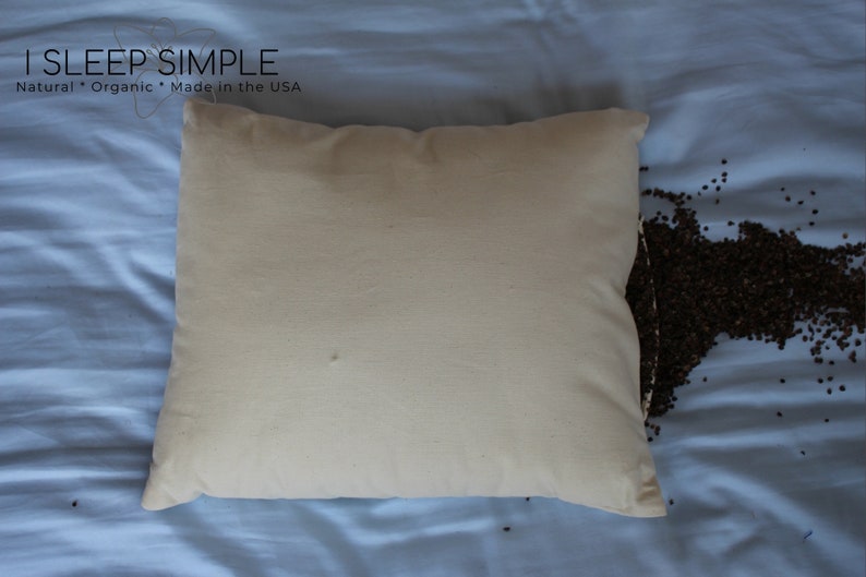 Peut inclure: Une taie d'oreiller blanche avec une fermeture &eacute;clair, remplie de coques de sarrasin. La taie d'oreiller est sur un drap bleu avec des coques de sarrasin &eacute;parpill&eacute;es autour. Le texte "I SLEEP SIMPLE" est imprim&eacute; sur le drap. Le texte "Natural * Organic * Made in the USA" est imprim&eacute; sous le nom de l'entreprise.