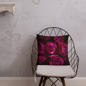 May include: A throw pillow featuring a close-up image of a bouquet of deep pink roses.