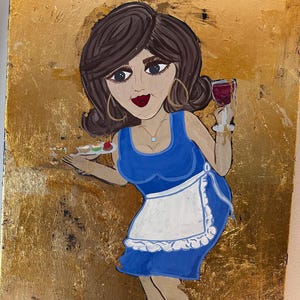 May include: A whimsical painting on a gold background depicts a woman in a blue dress and white apron, holding a tray of desserts and a glass of red wine. The woman has dark hair, large hoop earrings, and a turquoise necklace. The artwork has a cartoonish style.