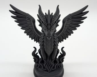 May include: A black dragon figurine with outstretched wings and a detailed, textured body. The dragon has horns and is perched atop a base with flame-like details. The figurine is a solid, matte black colour.
