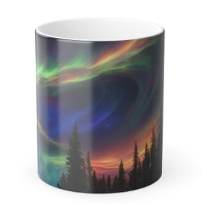 May include: A white ceramic mug with a colorful aurora borealis scene printed on it. The scene features a dark blue sky with green, orange, and purple aurora lights. Silhouettes of trees are visible in the foreground.