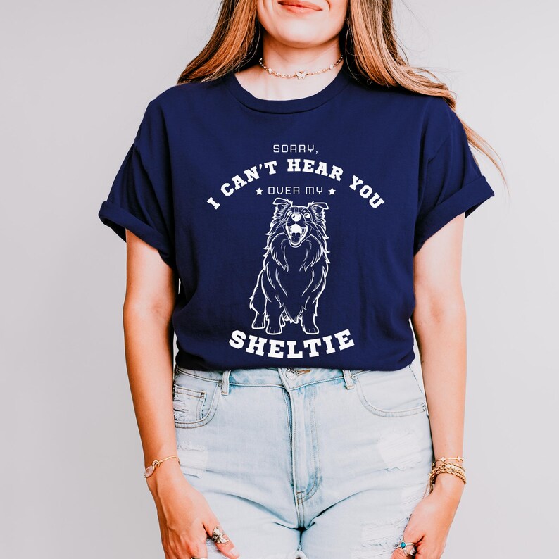 Peut inclure: Un t-shirt bleu marine avec un graphique blanc d'un chien Sheltie et le texte "D&eacute;sol&eacute;, je ne peux pas t'entendre par-dessus mon Sheltie".