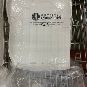 May include: White plastic bag with the text "ARTISTIC INDUSTRIES" and "USG Hydrostone-Distributed by Artistic Industries 2.5 lbs 5 lb 10 lbs 12.5 lbs 15 lbs" printed on it.