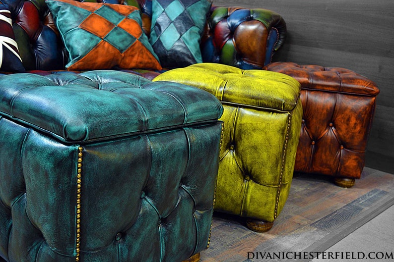 May include: Three tufted leather storage ottomans in teal, yellow, and brown. The ottomans are arranged in a row on a wooden floor.