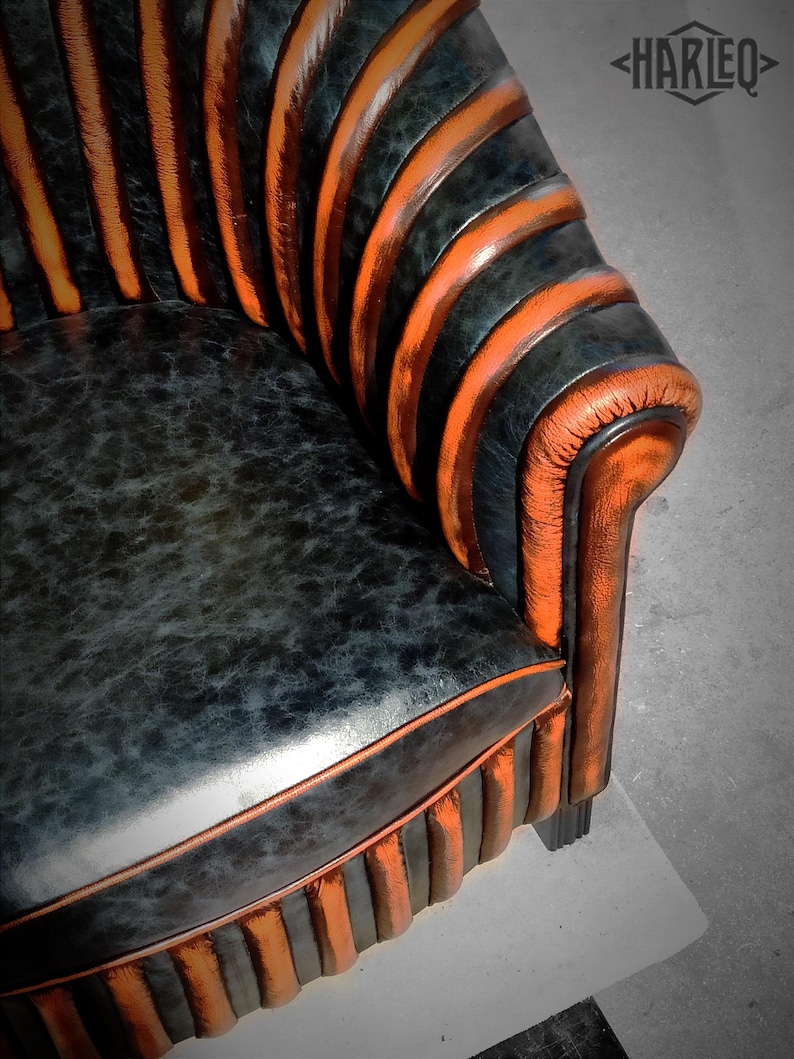 May include: A black and orange striped armchair with a tufted back and a curved, rounded seat. The chair is upholstered in a textured leather-like fabric.
