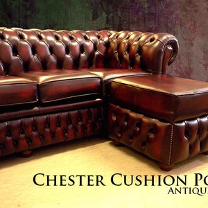 K&ouml;nnte beinhalten: Ein gro&szlig;es, rotes Chesterfield-Sofa aus Leder mit einer passenden Ottomane. Das Sofa hat ein gestepptes Design und ist in antikem Rot.