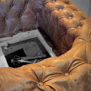 May include: A close-up of a brown leather sofa with button tufting. The sofa has a distressed appearance and is in the process of being assembled. The logo "HARLEQ" is visible in the upper right corner.