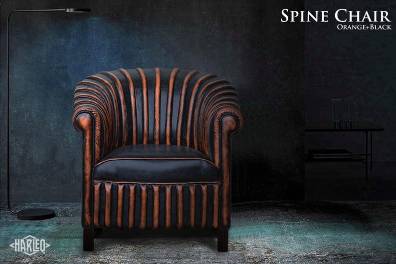 May include: A black leather armchair with orange stitching and a tufted back. The chair has a classic design and is upholstered in a durable leather. The chair is called "Spine Chair" and is available in orange and black.