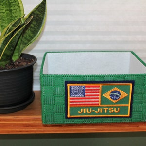 May include: Green woven storage box with a patch featuring the American and Brazilian flags and the text "JIU-JITSU".