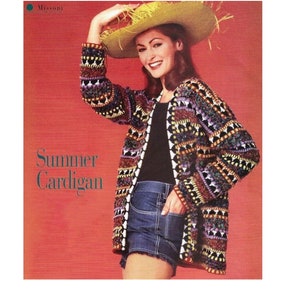 May include: A woman wearing a colourful crocheted cardigan with a wide-brimmed straw hat. The cardigan has a geometric pattern and is open at the front. The woman is wearing denim shorts and a black top. The text "Summer Cardigan" is printed on the image.