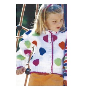 May include: A white knitted cardigan with colorful polka dots. The cardigan has a button closure and long sleeves. The sleeves have a striped pattern in red, white, and blue.