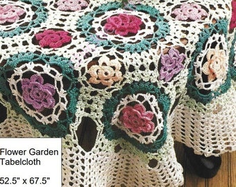May include: A white crocheted tablecloth with a floral design. The tablecloth features square motifs with pink, purple, and peach-colored flowers, framed by green and white borders. The dimensions are 52.5 inches by 67.5 inches.