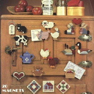 May include: A collection of 20 country-themed magnets made from plastic canvas. The magnets feature various farm animals, a teapot, a heart, and a house with the word "WELCOME". The image also includes apples, a can of Irish oatmeal, and a jar of flour.