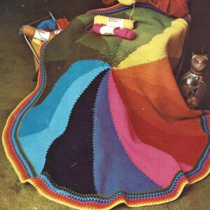May include: A colorful crocheted blanket with a rainbow pattern. The blanket is made with different colored yarn and has a scalloped edge.