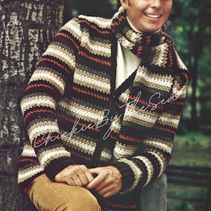 Könnte beinhalten: Gehäkeltes Strickjacken- und Schal-Set in einem gestreiften Muster aus Braun, Schwarz, Creme und Rot. Die Jacke hat eine Knopfleiste und lange Ärmel. Der Schal ist lang und rechteckig und passt zum Design der Jacke. Der Text "Chickie By the Sea" ist sichtbar.