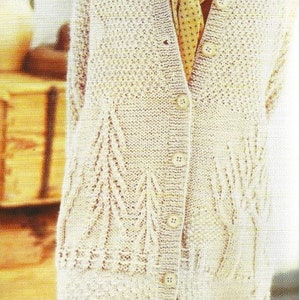 May include: A cream knitted cardigan with a button-up front and a delicate lace pattern. The cardigan has a V-neck and long sleeves.