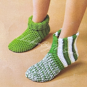 May include: A pair of handmade crochet socks. One sock is solid green, while the other features green and white stripes. The socks are designed to cover the foot and ankle, offering a cozy and warm feel. The crochet stitch is visible.
