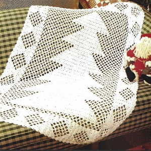 May include: White crocheted throw blanket with a geometric pattern. The blanket is draped over a plaid sofa.