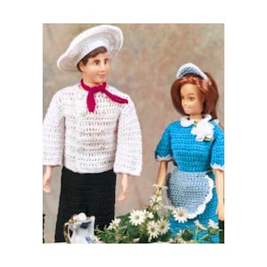 Op de afbeelding: Een gehaakte poppenoutfitset voor een pop met een witte koksmuts en jas, een rode sjaal, een zwarte broek en een blauwe jurk met een witte schort en een witte muts.