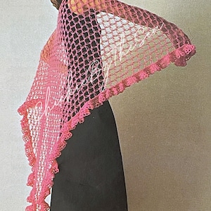 May include: A pink crocheted shawl with a lacy border. The shawl is draped over a person's shoulders and arms.