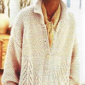 May include: A cream-coloured knitted cardigan with a button-up front and a cable knit pattern. The cardigan has a relaxed fit and long sleeves.