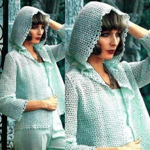 Puede incluir: Una chaqueta de ganchillo de color verde claro con capucha y bordes festoneados. La chaqueta está abierta por delante y tiene un corte holgado.