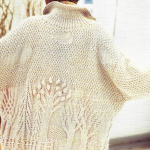 May include: A cream knitted cardigan with a textured design featuring trees and branches. The cardigan has a high neck and long sleeves.