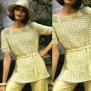 Pode incluir: Um top de crochê amarelo com decote redondo largo e mangas curtas. O top tem um cinto de crochê e um padrão delicado e vazado.