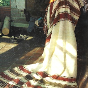 May include: A white ceramic mug with a black handle and the text "But First, Coffee" in a bold, black font. The mug is set against a neutral background, highlighting its simple design.