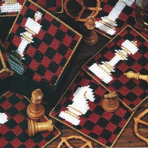 May include: Set of six crocheted coasters featuring a black and red checkerboard pattern with white chess pieces. The coasters are made with yarn and are perfect for adding a touch of whimsy to your home decor.