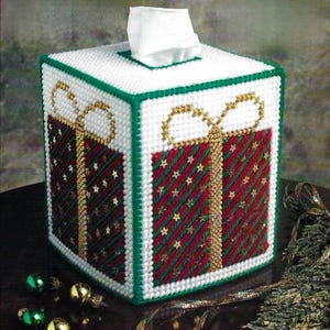 May include: A white tissue box cover with a green border and a red and green gift box design with gold ribbon and stars.