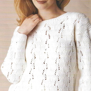 May include: A cream-coloured, long-sleeved jumper with a textured, open-weave design. The jumper has a round neck and a pattern of vertical, leaf-like shapes. The sleeves are long and fitted, and the overall style is classic and feminine.