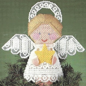 May include: A white angel Christmas tree topper with a halo, wings, and a yellow star. The angel has a white dress with lace trim and a blonde wig.