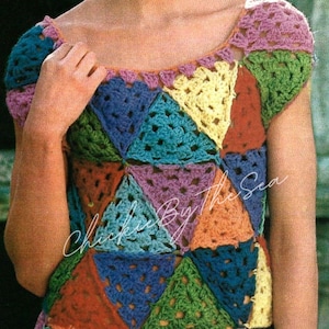 May include: A colourful crochet top with a geometric pattern of triangles in shades of blue, green, yellow, orange, and purple. The top has a scoop neck and short sleeves.