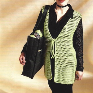 May include: A lime green crochet vest with a tie closure. The vest is open in the front and has a V-neck. The model is wearing a black top and black pants.