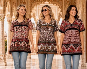 May include: Three short-sleeved tunics featuring intricate red, black, and white patterns with elephant motifs along the hem, paired with light blue denim jeans. Each tunic has a V-neckline with a lace-up detail and a relaxed, hip-length fit.