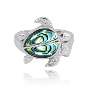 Può includere: Un anello d'argento con un design a forma di tartaruga in madreperla verde e blu.