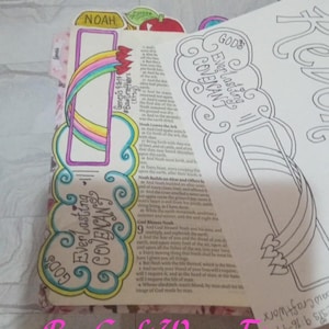 May include: Bible opened to a page with the words "God's Everlasting Covenant" and a rainbow illustration. The page is decorated with colorful designs and the name "Noah." The Etsy shop name "BawCraftWorx" is visible.