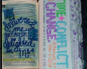 May include: A close-up of a Bible page with colorful handwritten text. The text reads "He delivered me because He delighted in me." The page is open to 1 Samuel 2:28. The next page has the words "Time + Conflict = Change" written in colorful letters. The date "Dec. 6, 2018" is written below the words.