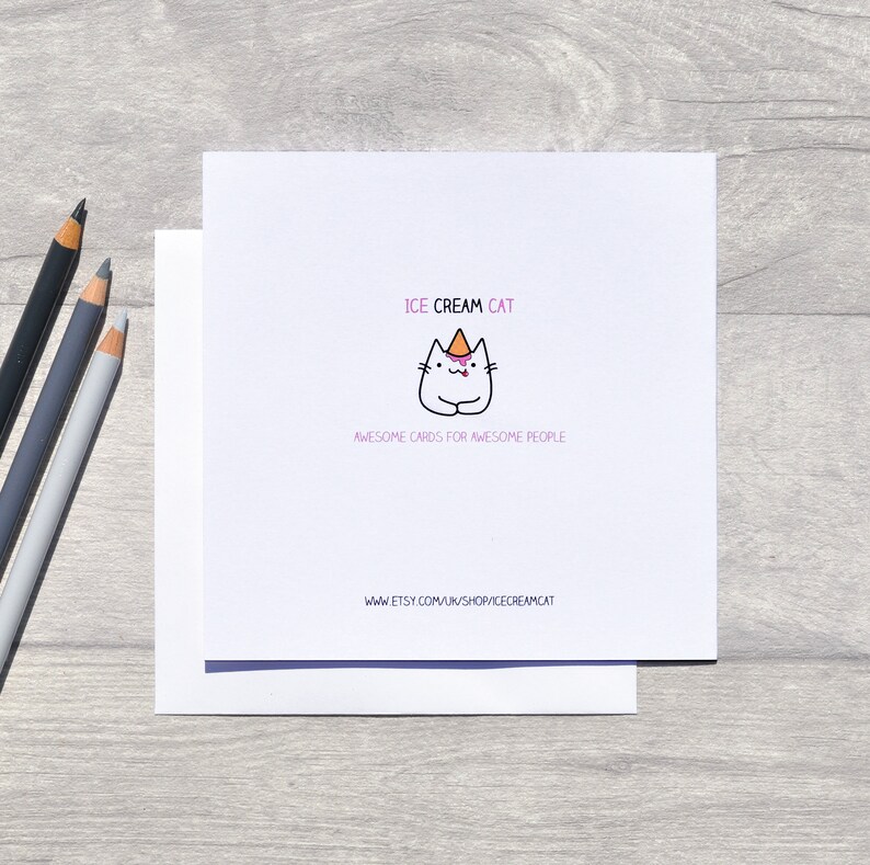 May include: A white card with a cartoon cat wearing a pink and orange ice cream cone hat. The text "ICE CREAM CAT" is above the cat and "AWESOME CARDS FOR AWESOME PEOPLE" is below the cat. The text "www.etsy.com/uk/shop/icecreamcat" is at the bottom of the card.