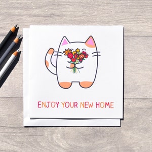 Puede incluir: Un gato blanco con orejas rosas sostiene un ramo de flores coloridas. La tarjeta dice "Disfruta de tu nuevo hogar".
