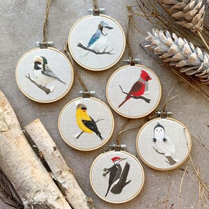 Décoration sapin Noël broderie oiseaux habit hiver sur cercle à broder geai bleu mésange chardonneret cardinal pic bois harfang