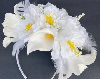 Tocado floral blanco con detalle de plumas.