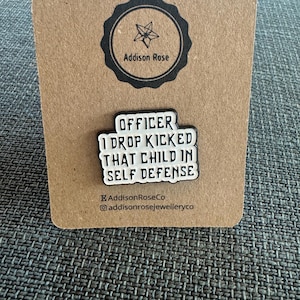 Insignia de esmalte con el mensaje "Oficial al que tiré y le di una patada a ese niño en defensa propia"