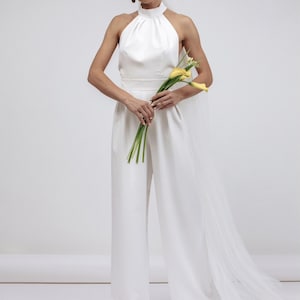 Women&#39;s white jumpsuit with an open back made of dense satin