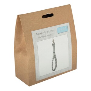 May include: A brown paper craft kit bag with a handle cutout. The label features the text "Make Your Own Macramé Keyring" and "Trimits" above an image of a light gray macramé keyring with a metal lobster clasp and a looped cord design.